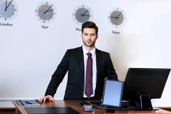 Businessman behind a desk standing