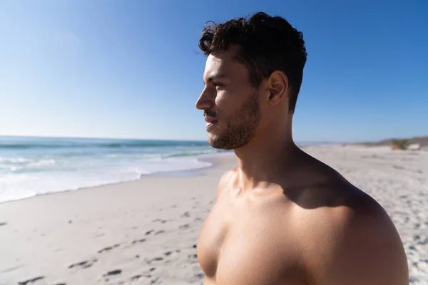 Guy at beach looking at sun