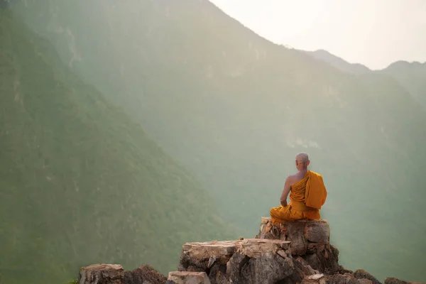 Himalayan monk meditating on rock