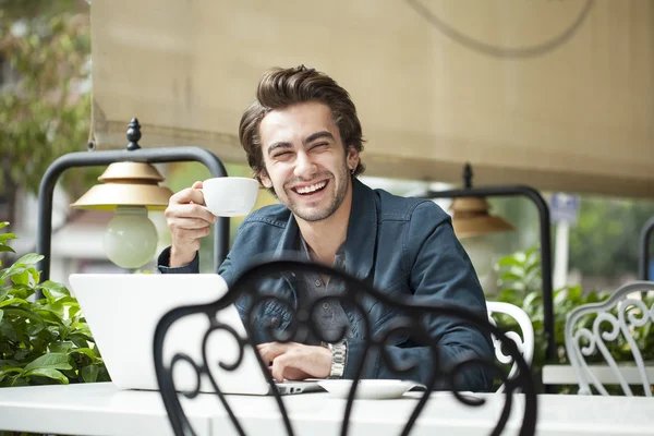 Man smiling and happily drinking coffee