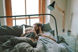 Man kissing woman in bed