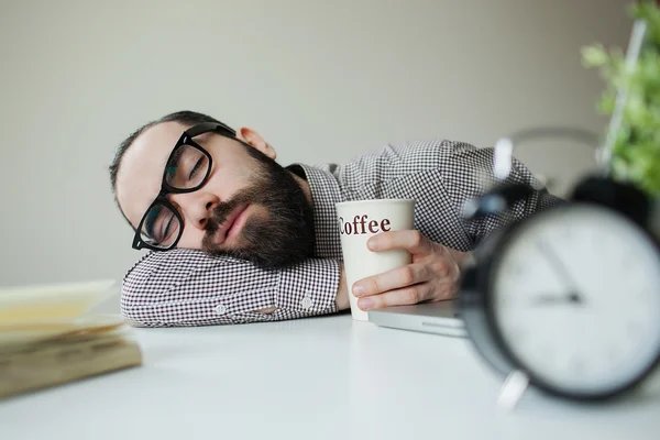 Man sleeping with coffee in hand
