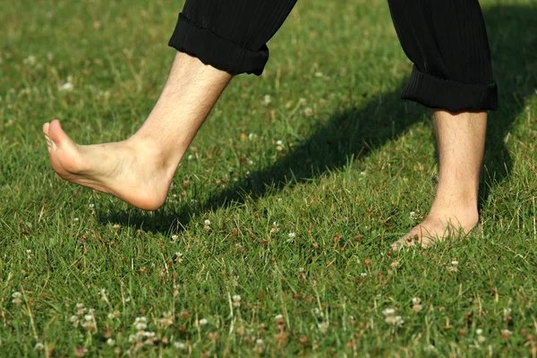 Man walking barefoot in grass