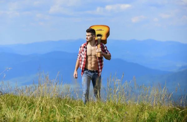 Man with guitar mountain hiking