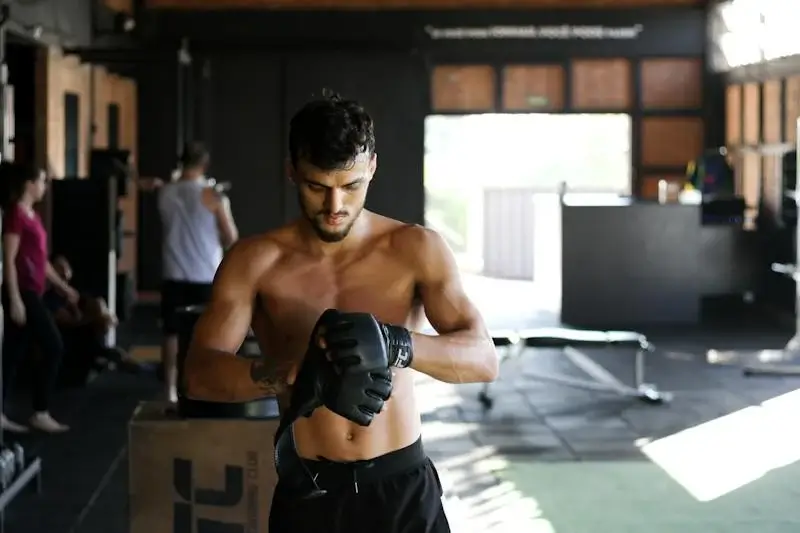 Martial artist in dojo putting on gloves