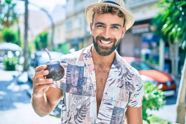 Happy vacation-goer drinking yerba mate with metal straw